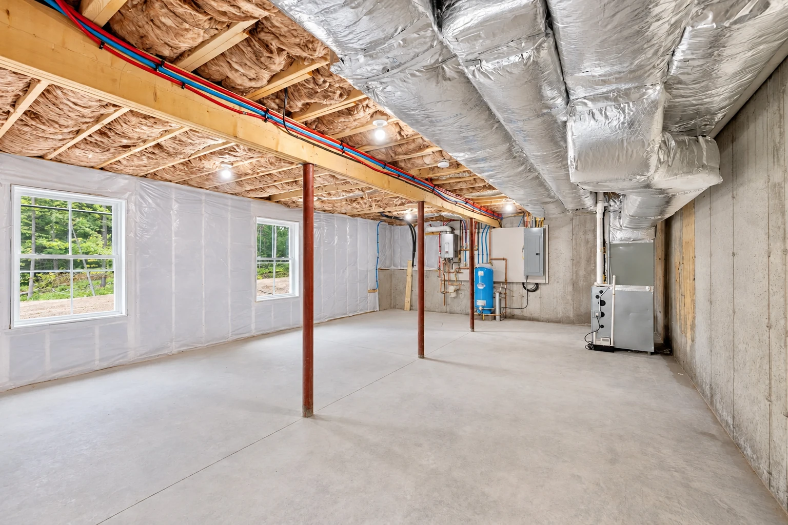 Basement with exposed ceiling joists, fiberglass insulation, large silver ducts, and plastic-covered walls.